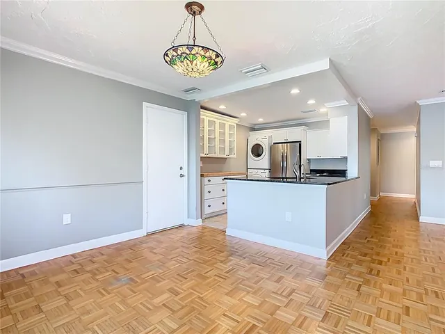 a view of kitchen with stainless steel appliances cabinets and window
