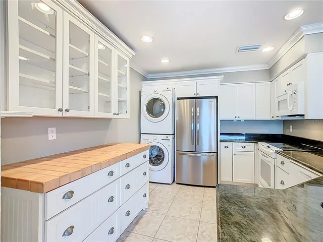 a kitchen with stainless steel appliances granite countertop a refrigerator and a stove top oven