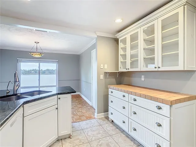a kitchen with granite countertop white cabinets and window