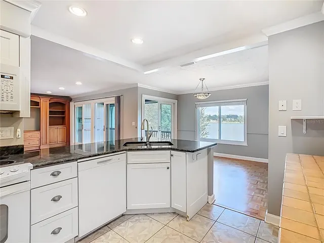 a kitchen with granite countertop a sink and cabinets