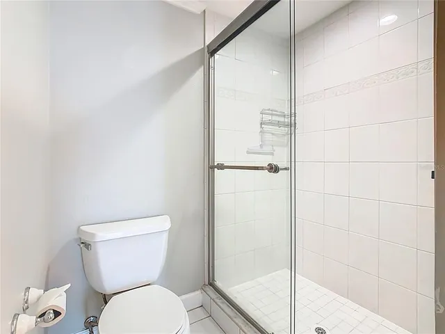 a white toilet sitting next to a shower