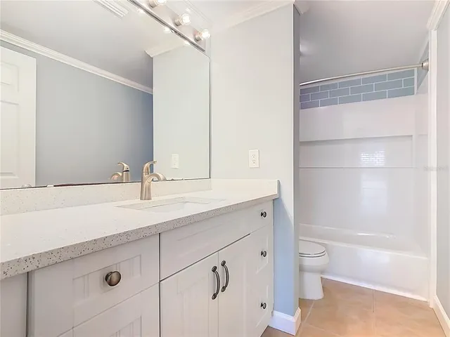 a bathroom with a bathtub shower sink vanity and toilet