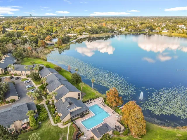an aerial view of ocean and residential houses with outdoor space