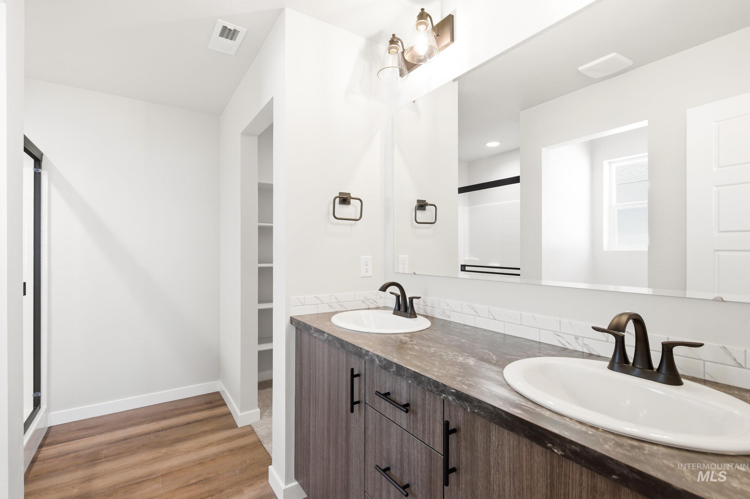 12805 Decatur Street Nampa, ID 83651 - Photo 18 of 20 Double vanity with two undermount sinks and bronze-finish faucets, set against a subway tile backsplash
