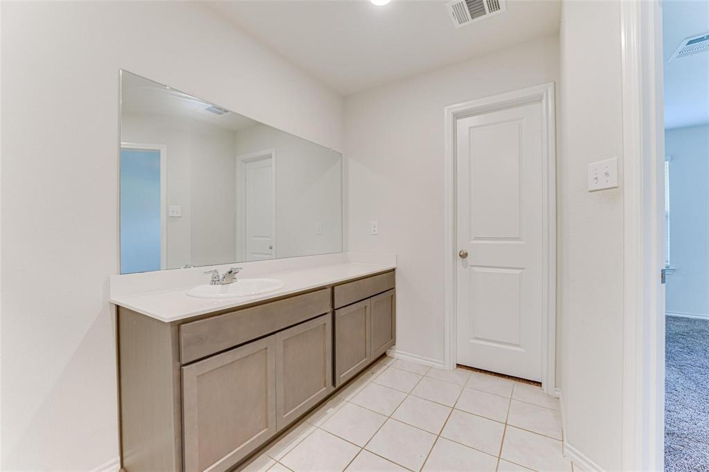 517 Milo Way Royse City, TX 75189 - Photo 33 of 34 Vanity area featuring an integrated sink, light-toned countertop, and expansive wall-mounted mirror