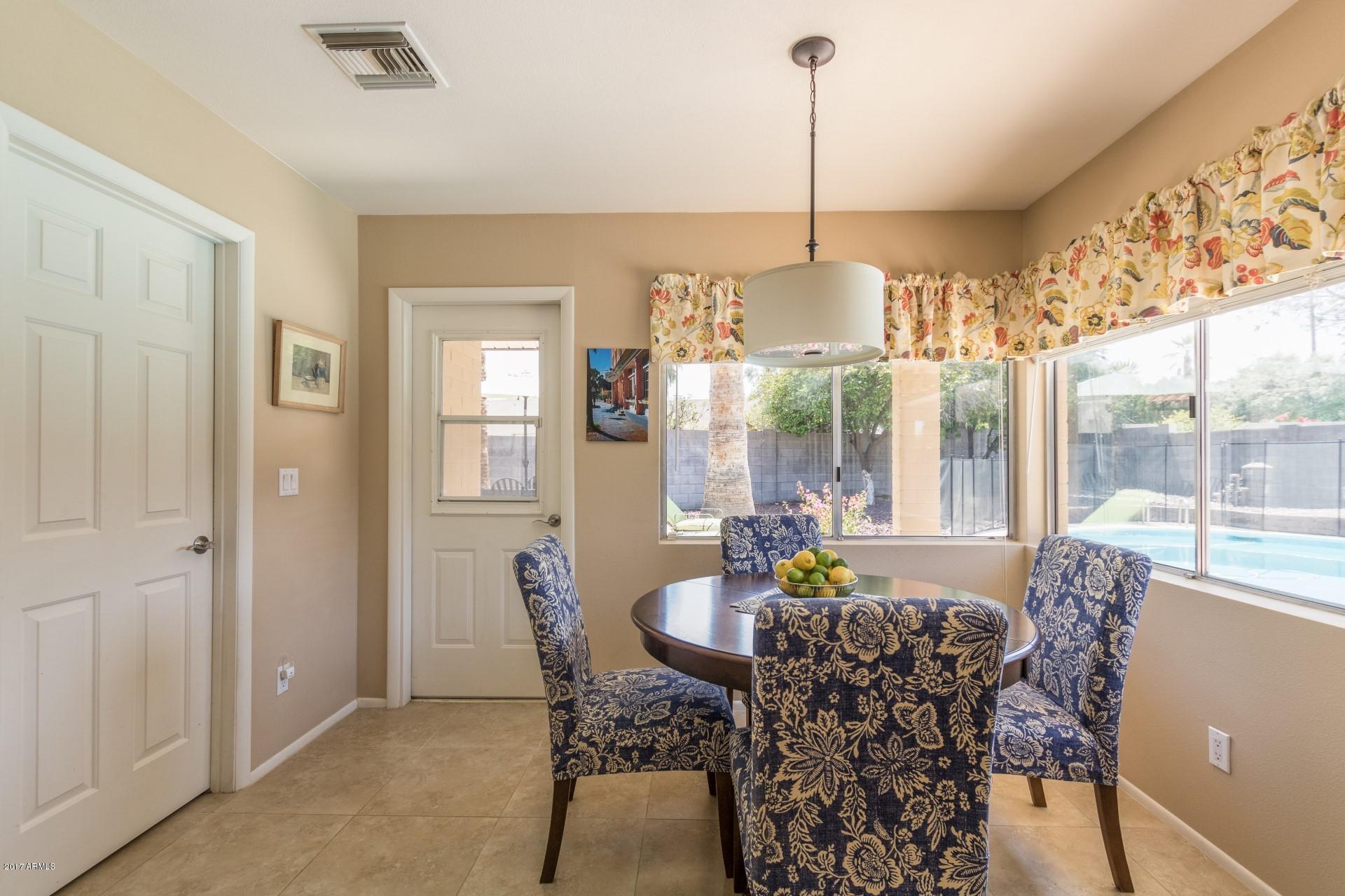3717 East Yucca Street Phoenix, AZ 85028 - Photo 20 of 36 a dining room with furniture a chandelier and wooden floor