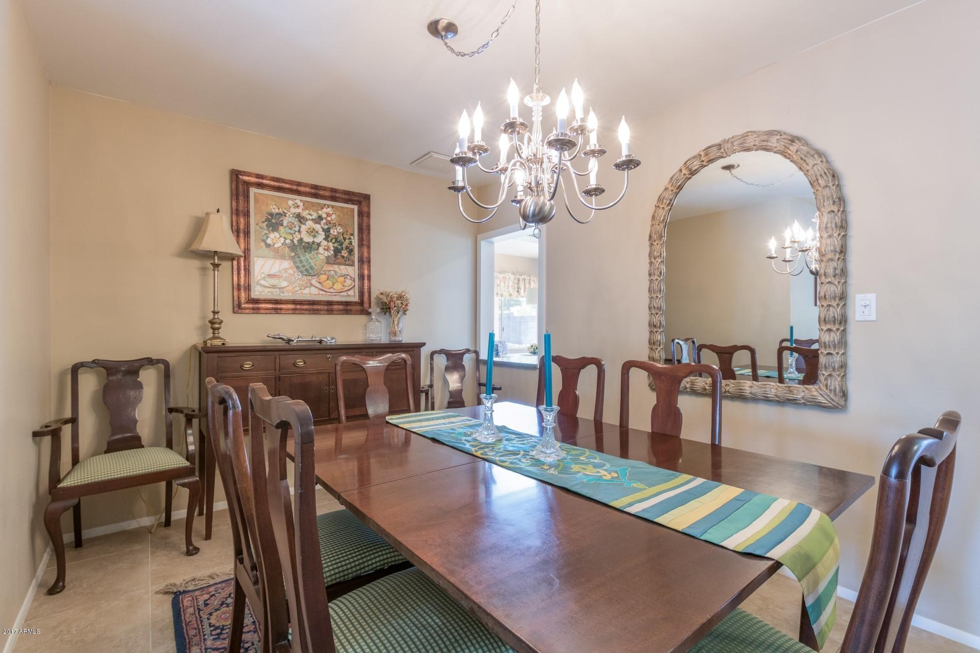 3717 East Yucca Street Phoenix, AZ 85028 - Photo 9 of 36 a view of a dining room with furniture a chandelier and wooden floor