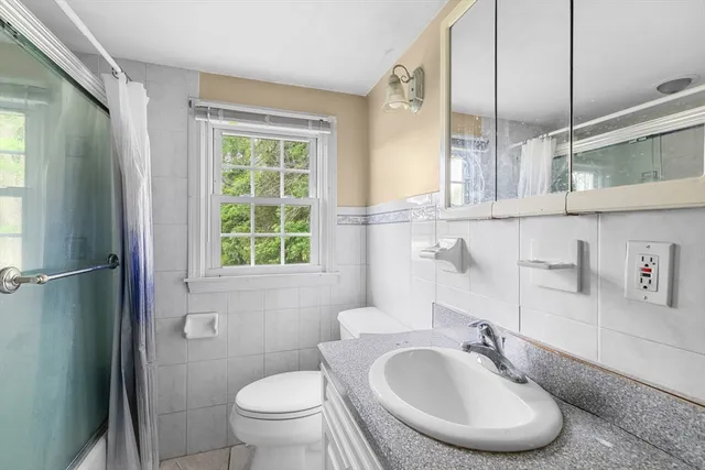 a bathroom with a sink toilet and a mirror