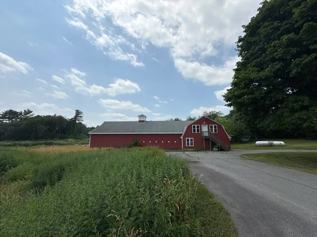 a view of a big house with a big yard and large trees