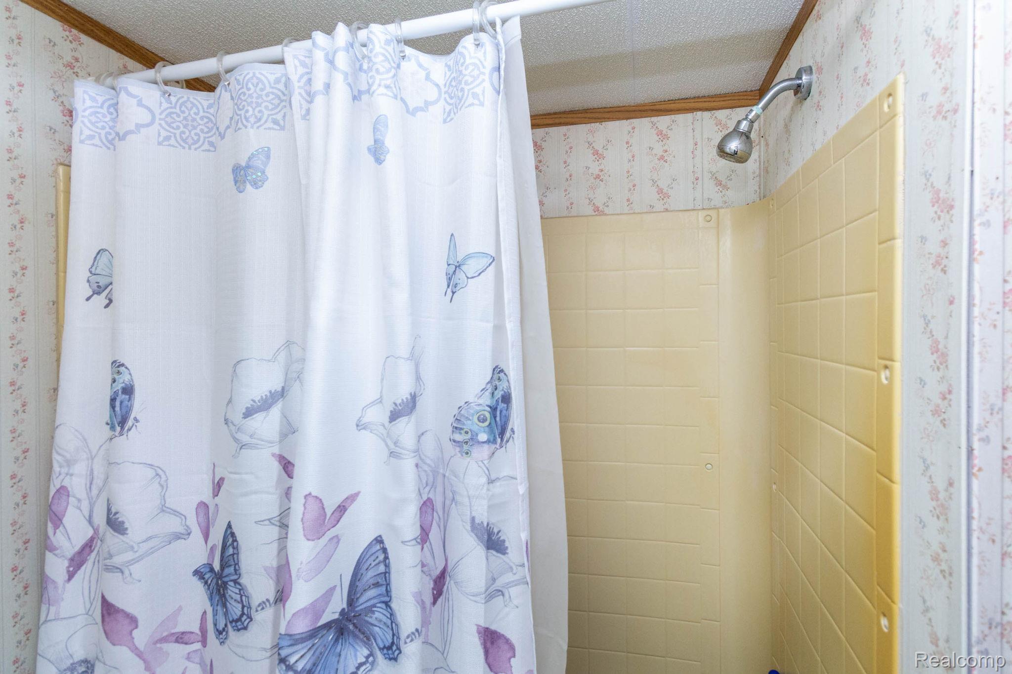 38 South Force Road Attica, MI 48412 - Photo 26 of 53 Shower featuring textured yellow wall panels and a wall-mounted shower head