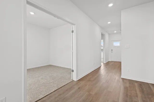 a kitchen with white cabinets stainless steel appliances and wooden floor