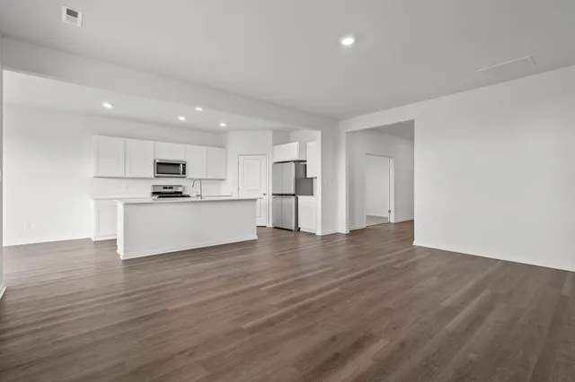 a view of a kitchen with wooden floor and a window