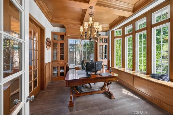 a hallway with wooden floor chandelier and entryway