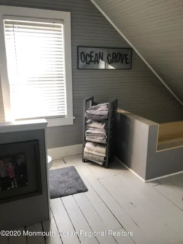 a view of stairs and an empty room with wooden floor