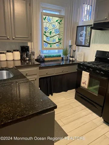 a kitchen with stainless steel appliances granite countertop a sink and a stove