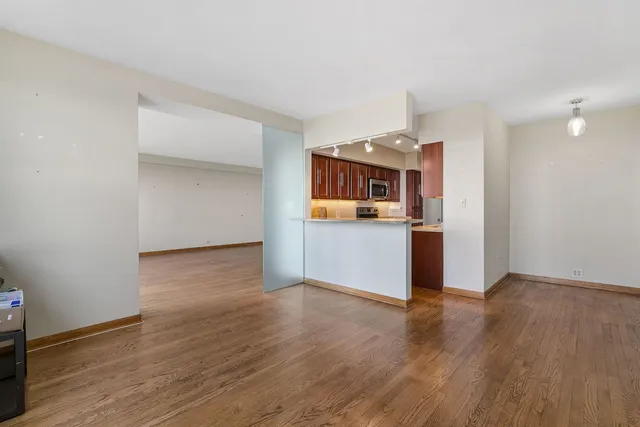 a view of a kitchen with a microwave and wooden floor