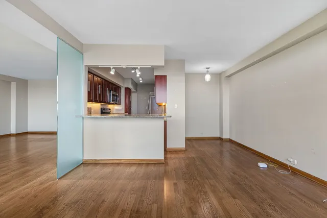 a view of a kitchen with wooden floor and a window