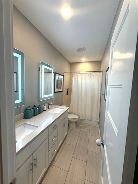 928 Azalea Drive Franklin, TX 77856 - Photo 26 of 37 a bathroom with a double vanity sink toilet mirror and window