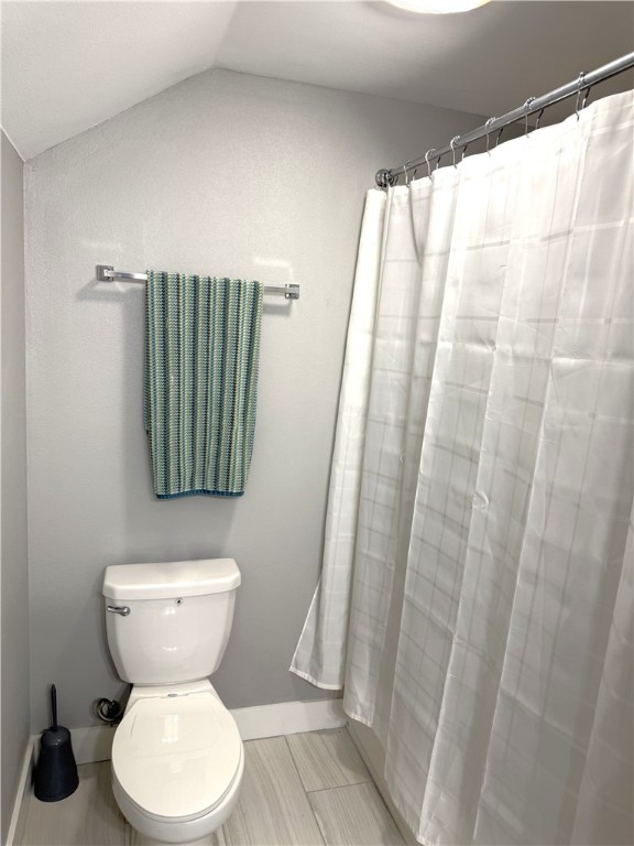 928 Azalea Drive Franklin, TX 77856 - Photo 32 of 37 a bathroom with a toilet and a shower curtain