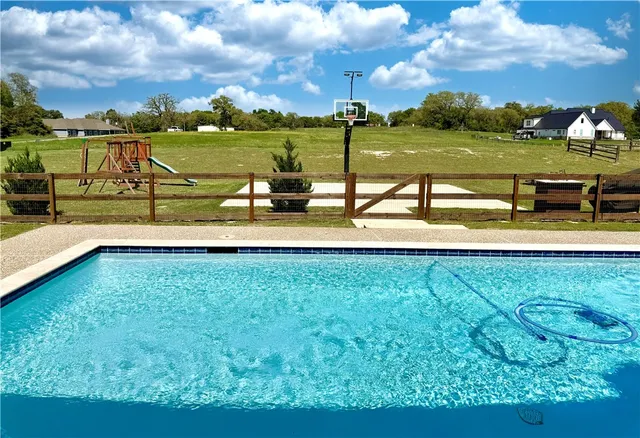 a view of a house with swimming pool and sitting area