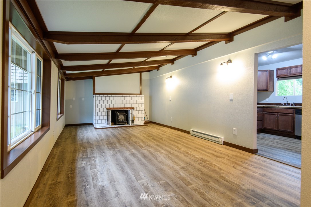 2710 Callow Road Lake Stevens, WA 98258 - Photo 16 of 37 a view of an empty room with wooden floor a fireplace and a window