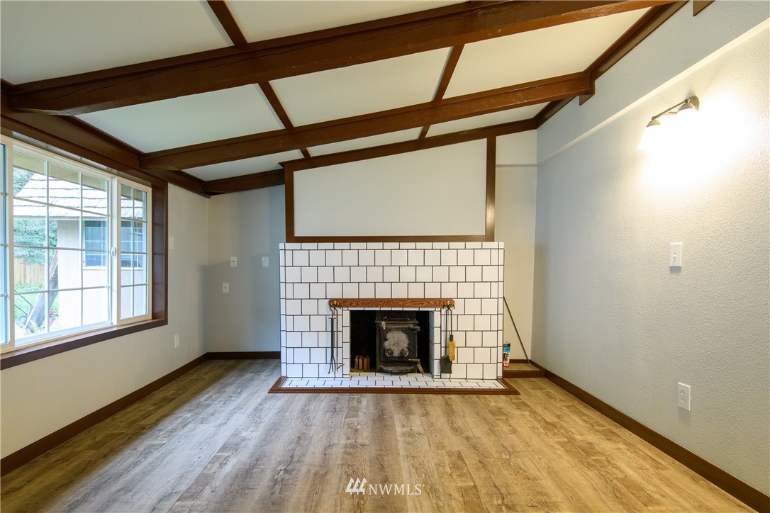 2710 Callow Road Lake Stevens, WA 98258 - Photo 17 of 37 a view of an empty room with wooden floor fireplace and a window