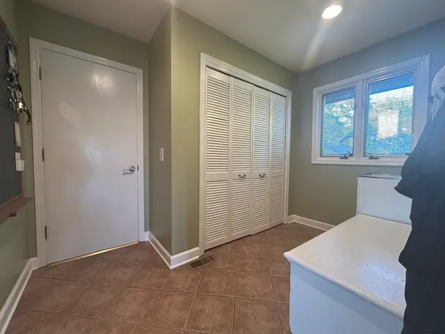 an empty room with windows and closet