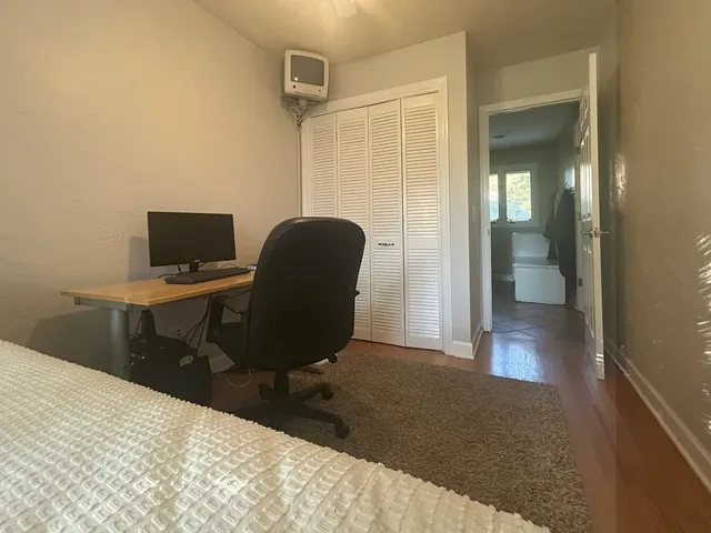 a view of a workspace with furniture and a window