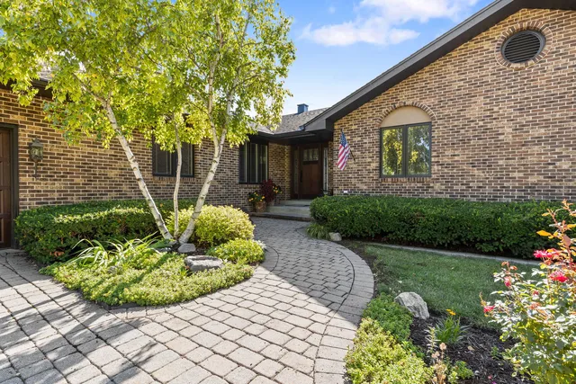 a view of a house with a yard and potted plants