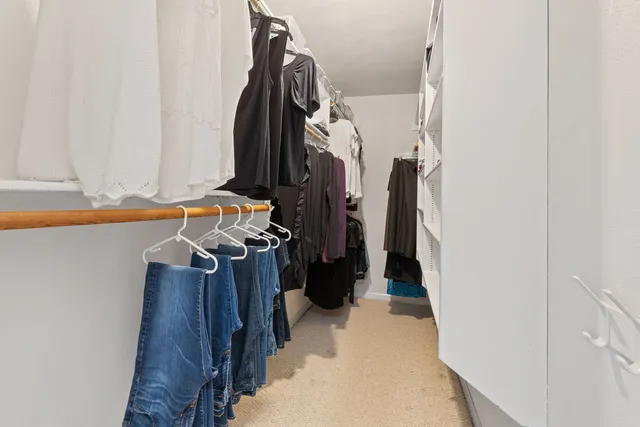 a view of walk in closet with clothes and shoes