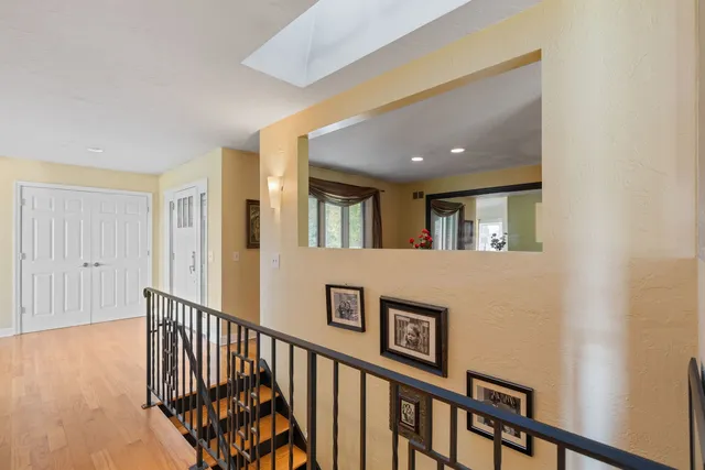 a view of a hallway with wooden floor and windows