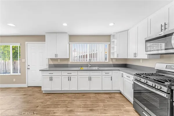 a kitchen with granite countertop a stove sink and cabinets