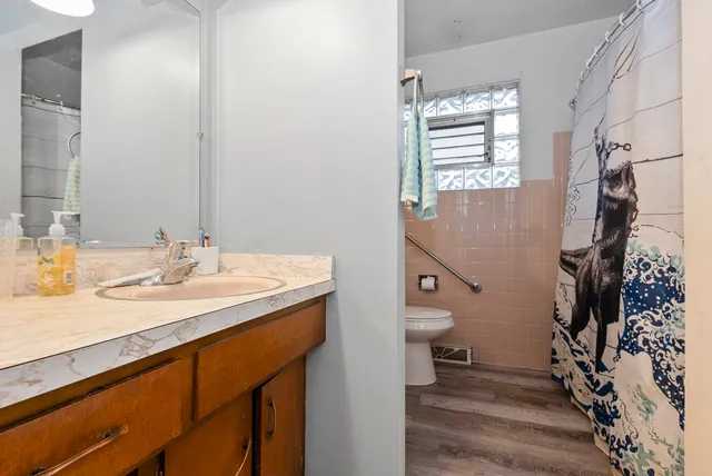 a bathroom with a sink a toilet and shower