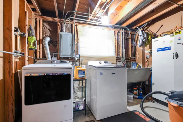 a view of washer and dryer with bathroom in the background