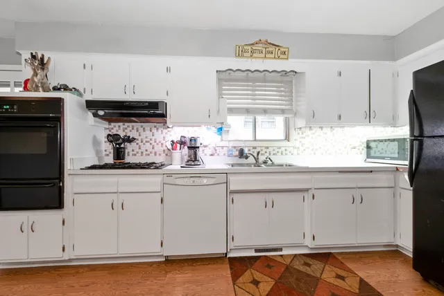 a kitchen with granite countertop white cabinets and white appliances