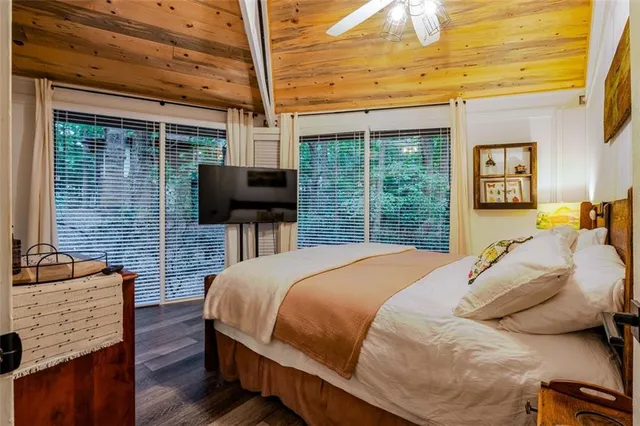 a bedroom with a bed flat screen tv and a window