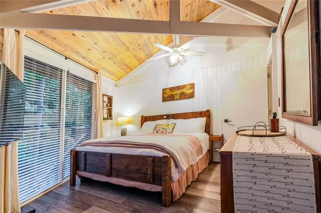 a bedroom with a bed and a dresser next to a window