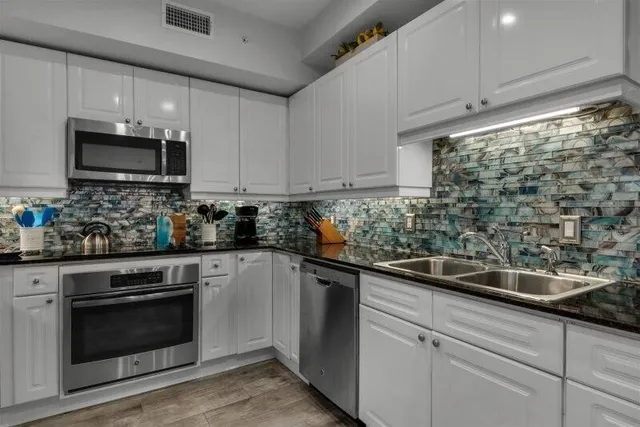 a kitchen with sink a microwave and cabinets