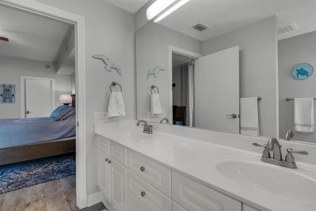 a en suite bathroom with a double vanity sink and a mirror