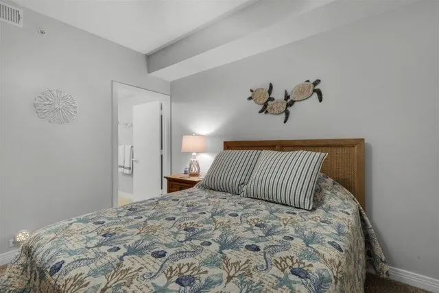 a bedroom with a large bed and wooden floor