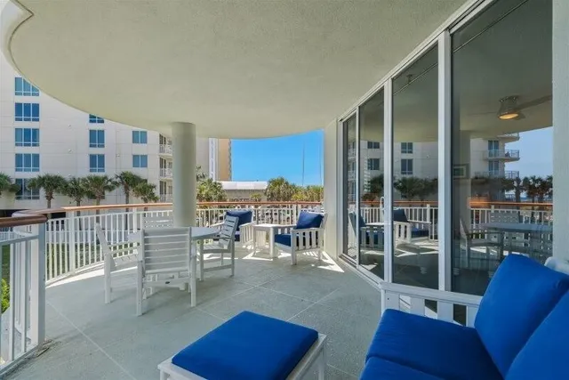 a living room with furniture a floor to ceiling window and kitchen view