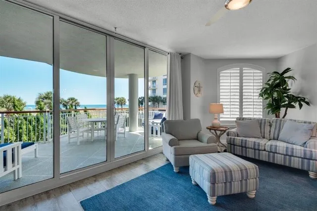 a living room with furniture and a floor to ceiling window