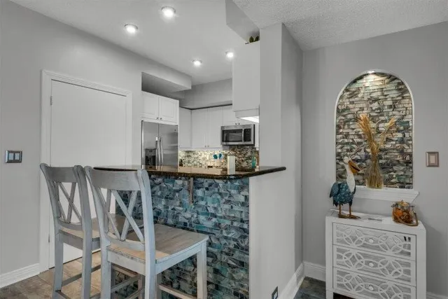 a kitchen with stainless steel appliances kitchen island granite countertop a refrigerator and microwave