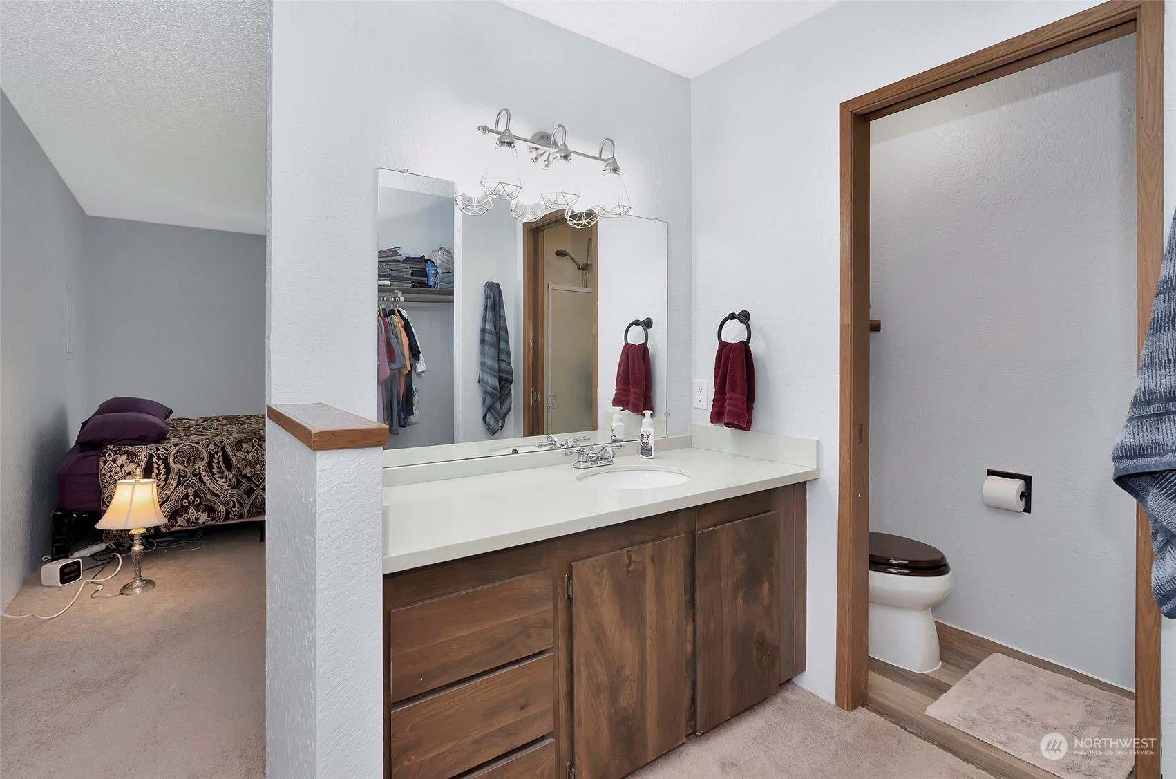 14401 Southeast Petrovitsky Road, Unit E205 Renton, WA 98058 - Photo 18 of 28 a en suite bathroom with a double vanity sink and a mirror