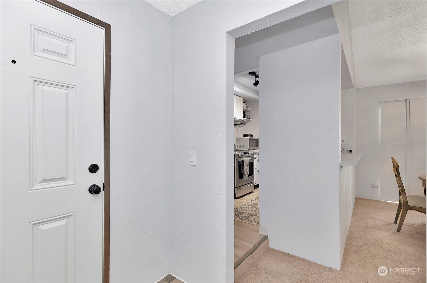 14401 Southeast Petrovitsky Road, Unit E205 Renton, WA 98058 - Photo 3 of 28 a view of a hallway with cabinets and wooden floor