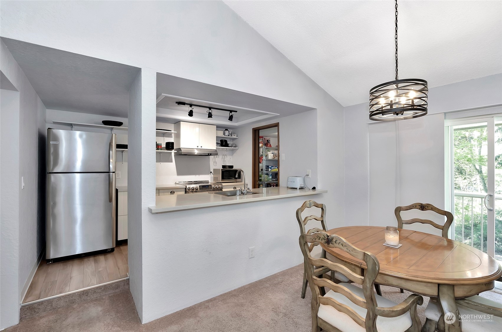 14401 Southeast Petrovitsky Road, Unit E205 Renton, WA 98058 - Photo 4 of 28 a kitchen with stainless steel appliances granite countertop a dining table and chairs
