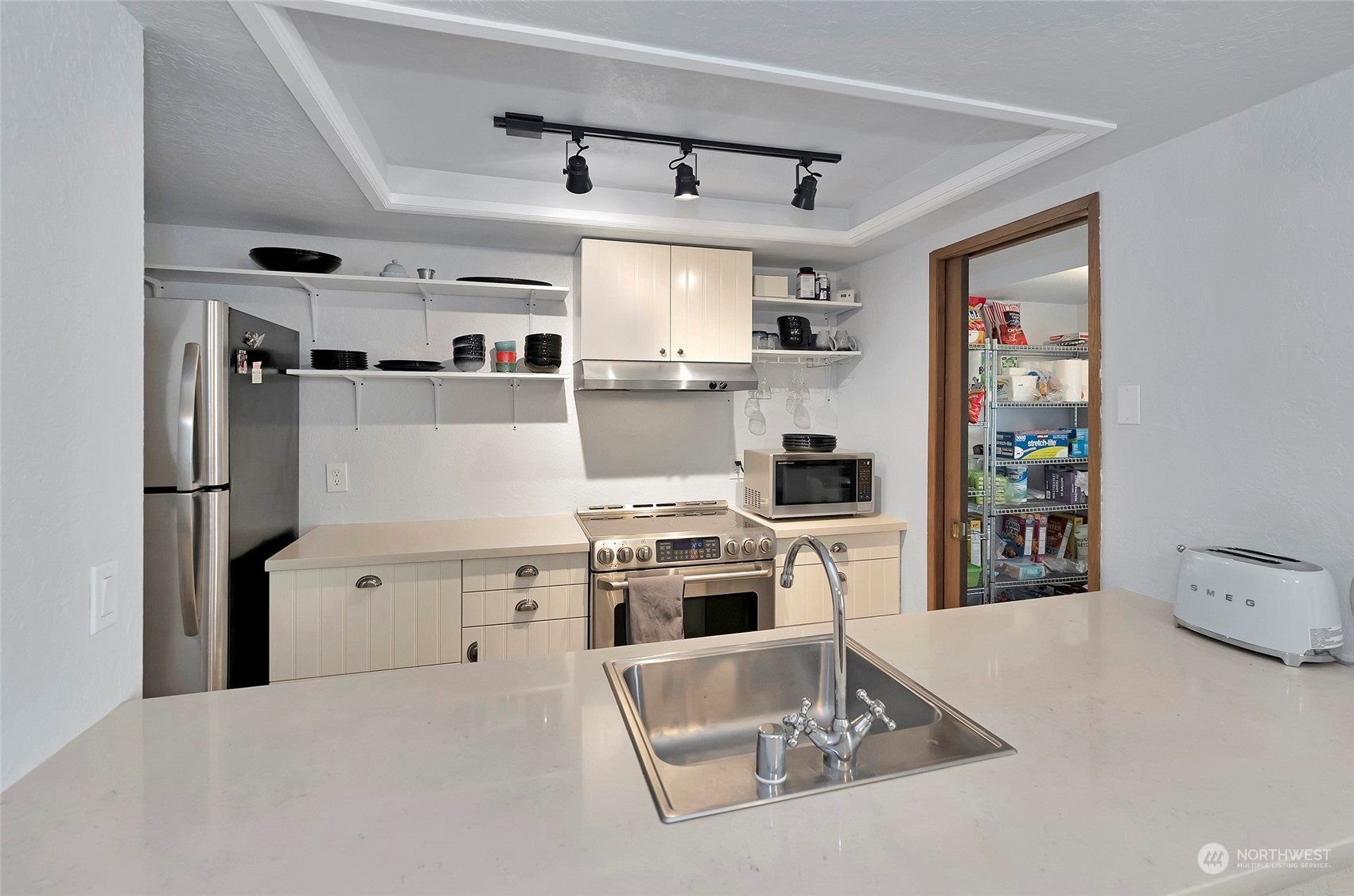 14401 Southeast Petrovitsky Road, Unit E205 Renton, WA 98058 - Photo 6 of 28 a kitchen with cabinets and stainless steel appliances