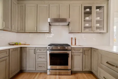 a kitchen with granite countertop white cabinets and white appliances