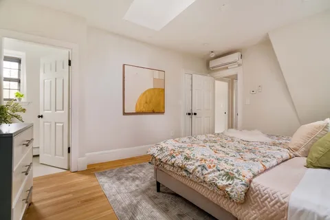 a bedroom with a bed and a painting on the wall