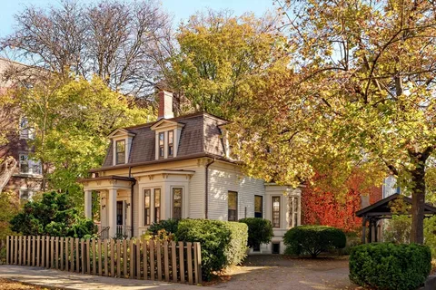a front view of a house with a tree
